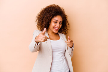 young african american woman isolated on beige background cheerful smiles pointing to front.
