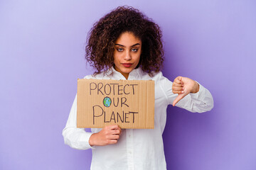 Wall Mural - Young African American woman holding a girl power placard isolated on purple background showing a dislike gesture, thumbs down. Disagreement concept.