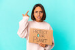© Asier - Young hispanic mixed race woman holding a protect our planet cardboard showing a disappointment gesture with forefinger.