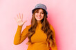 Young caucasian woman wearing fishermans hat isolated smiling cheerful showing number five with fingers.