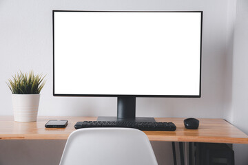 Wall Mural - Computer monitor with white blank screen on the business desk with wireless mouse, keyboard at home office over white wall background, Photo of equipment contemporary workspace