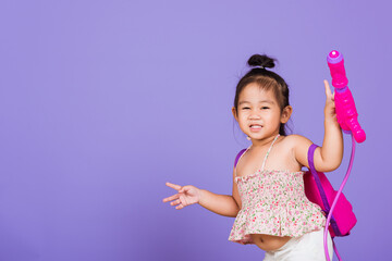 thai child funny hold toy water pistol and smile, happy asian little girl holding plastic water gun,