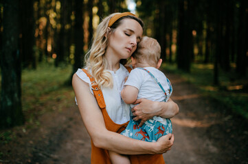 Wall Mural - Young mother hugging her son in the forest