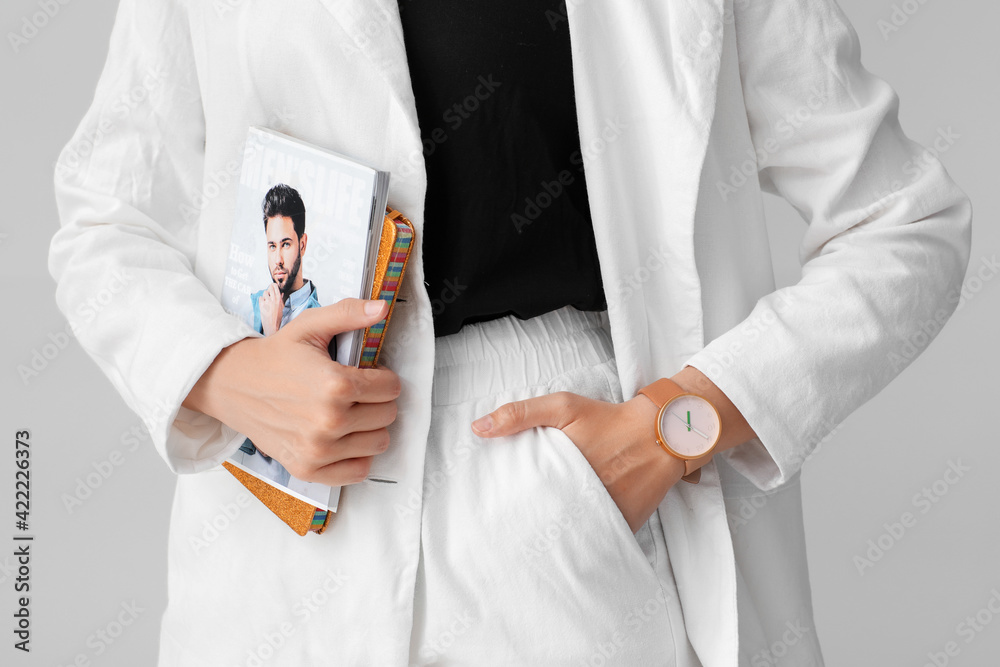 Woman with stylish wrist watch on light background
