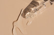 close up of pipette with pouring liquid serum and shadows