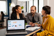 © DC Studio - Team of colleagues employees cooperating sitting at desk in startup company office analysing graphs, behind laptop. Business coworkers planning start up business project, brainstorming in wokrplace
