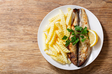 Wall Mural - plate of fried fish with french fries, top view