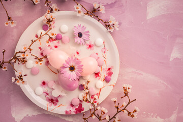 Wall Mural - Pink Easter eggs with blooming branch and sweets for Easter and spring