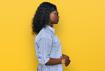 Poster - Beautiful african young woman wearing casual clothes and glasses looking to side, relax profile pose with natural face and confident smile.