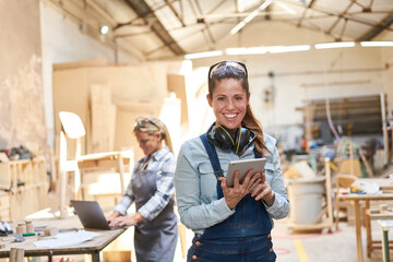 Handwerker Frau in Werkstatt mit Tablet Computer