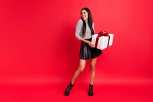 Full Body Photo Of Cheerful Joyful Girl Look Empty Space Hold Gift Box Holiday Present Isolated On Red Color Background