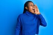 © Krakenimages.com - Young african american woman wearing casual clothes shouting and screaming loud to side with hand on mouth. communication concept.