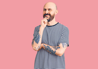 Sticker - Young handsome man wearing casual clothes looking confident at the camera with smile with crossed arms and hand raised on chin. thinking positive.