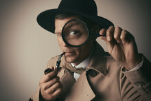 Male Detective With Smoking Pipe Looking Through Magnifying Glass On Beige Background