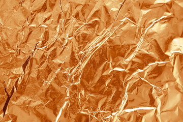 Shiny brown foil texture background, pattern of wrapping paper with crumpled and wavy.