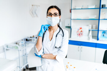 Portrait of a female doctor and her office with a stethoscope, she is smiling and looking at the camera, professional, health and modern medicine