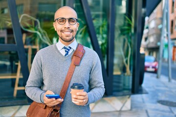 Sticker - Young african american businessman using smartphone and drinking take away coffee at the city.