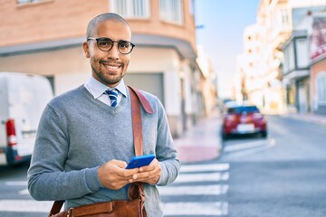 Sticker - Young african american businessman smiling happy using smartphone at the city.