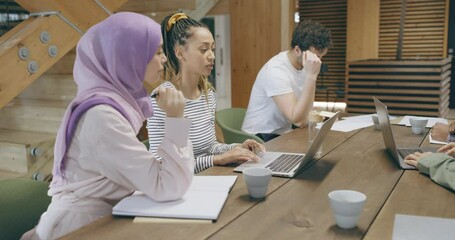 Wall Mural - Diverse businesswomen using a 
laptop during an office meeting