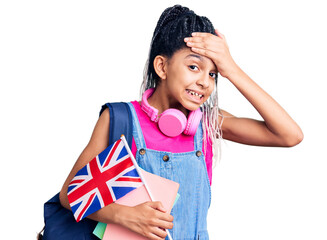 Poster - Cute african american girl wearing student backpack holding united kingdom flag stressed and frustrated with hand on head, surprised and angry face