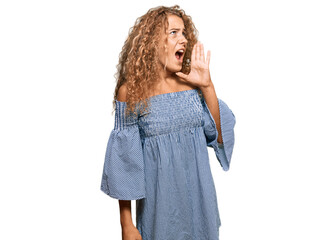 Wall Mural - Beautiful caucasian teenager girl wearing summer dress shouting and screaming loud to side with hand on mouth. communication concept.