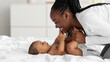 © Prostock-studio - African American mom playing in bed with her black baby