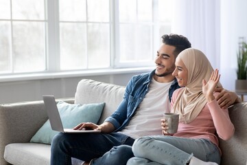 Wall Mural - Happy man and woman waving at laptop screen