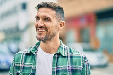 Young caucasian man smiling happy standing at the city.