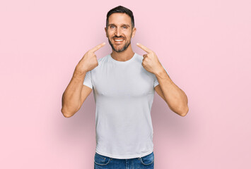 Canvas Print - Handsome man with beard wearing casual white t shirt smiling cheerful showing and pointing with fingers teeth and mouth. dental health concept.