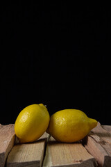 Lemon on a dark background. Two lemons on a wooden background. Creative photo of lemon.