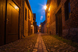 Fototapeta Uliczki - A small narrow alley in an old village at night, Beelitz, Brandenburg, Germany