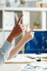 Wall Mural - Business people sitting at meeting table and pointing with finger to ask speaker a question