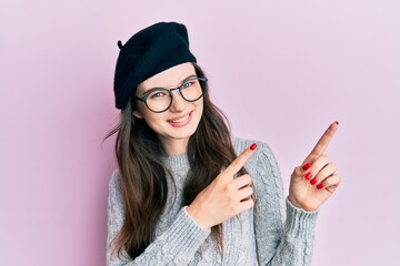 Sticker - Young beautiful caucasian girl wearing french look with beret smiling and looking at the camera pointing with two hands and fingers to the side.