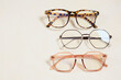 © Natasha - several fashionable stylish glasses on a beige background place copy top view, optics store