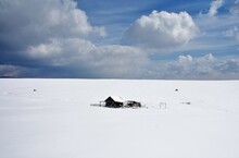 A Wooden Hut Left On The Field In Winter