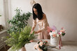 © Natalia - florist girl at work brunette collects a bouquet of flowers on the table
