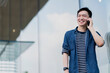 © whyframeshot - young smart attractive asian confident male wearing casul cloth hand hold smartphone connect communication near modern building smart technology ideas concept