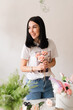© Natalia - brunette girl in white t-shirt collects a bouquet of flowers from roses florist at work