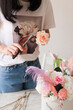 © Natalia - the work of the florist closeup brunette girl in a t-shirt with flowers cuts a rose