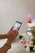 © Natalia - phone in female hands photographs a bouquet of flowers