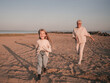 Grandmother runs after her granddaughter on the beach