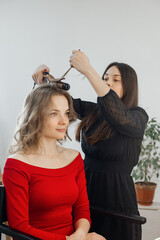 master makes a hairstyle for a girl, beautiful curls