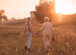 Grandmother with her adult daughter walk and hold hands in nature