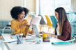 © nenetus - Casual multiethnic business women working with laptops while talking of they new projects together in coworking place.