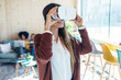 © nenetus - Modern young entrepreneur woman using virtual reality headset and enjoying the moment in a coworking place.