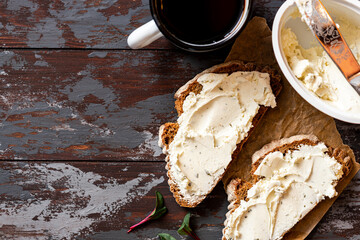 Sticker - Rustic breakfast. Sandwich with soft cheese and rye bread on a dark wooden background top view. Ricotta sandwich and coffee. Copy space for text. 