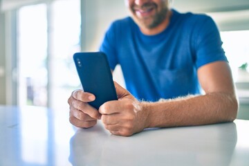 Sticker - Young irish man smiling happy using smartphone sitting on the table at home.