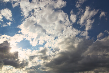 Wall Mural - dramatic blue sky with rays and white clouds