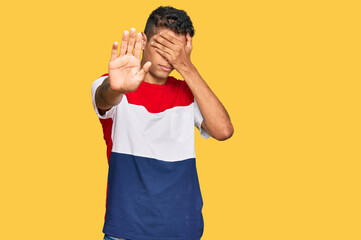 Canvas Print - Young handsome african american man wearing casual clothes covering eyes with hands and doing stop gesture with sad and fear expression. embarrassed and negative concept.