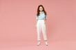 © ViDi Studio - Full length body of young student positive smiling happy caucasian european redhead woman 20s wearing blue shirt pants standing looking camera isolated on pastel pink color background studio portrait.